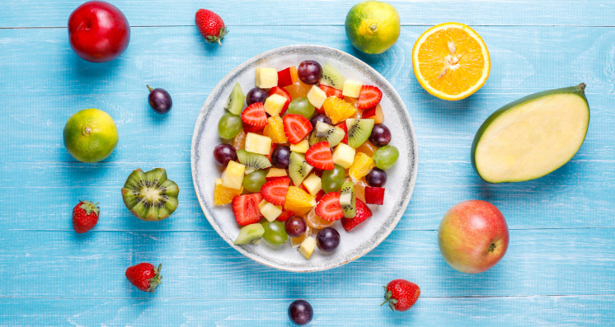 Gyümölcssaláta sokféle gyümölcsből, világoskék háttérrel