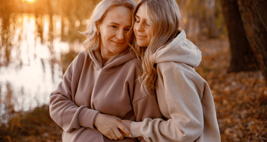 Anya és lánya ölelkeznek a természetben