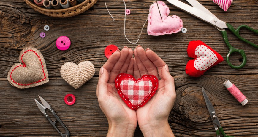 Kézzel készített szív ajándék, az asztalon ollók és még több szív
